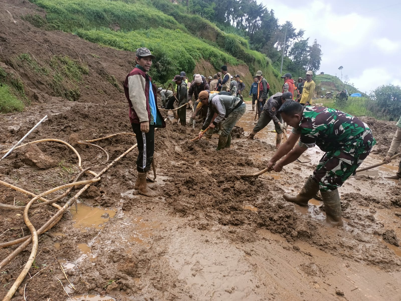 Proses pembersihan material longsor yang sempat menutup badan jalan menghubungkan Kecamatan Watumalang-Dieng, Kejajar, Rabu (11/12/2024).