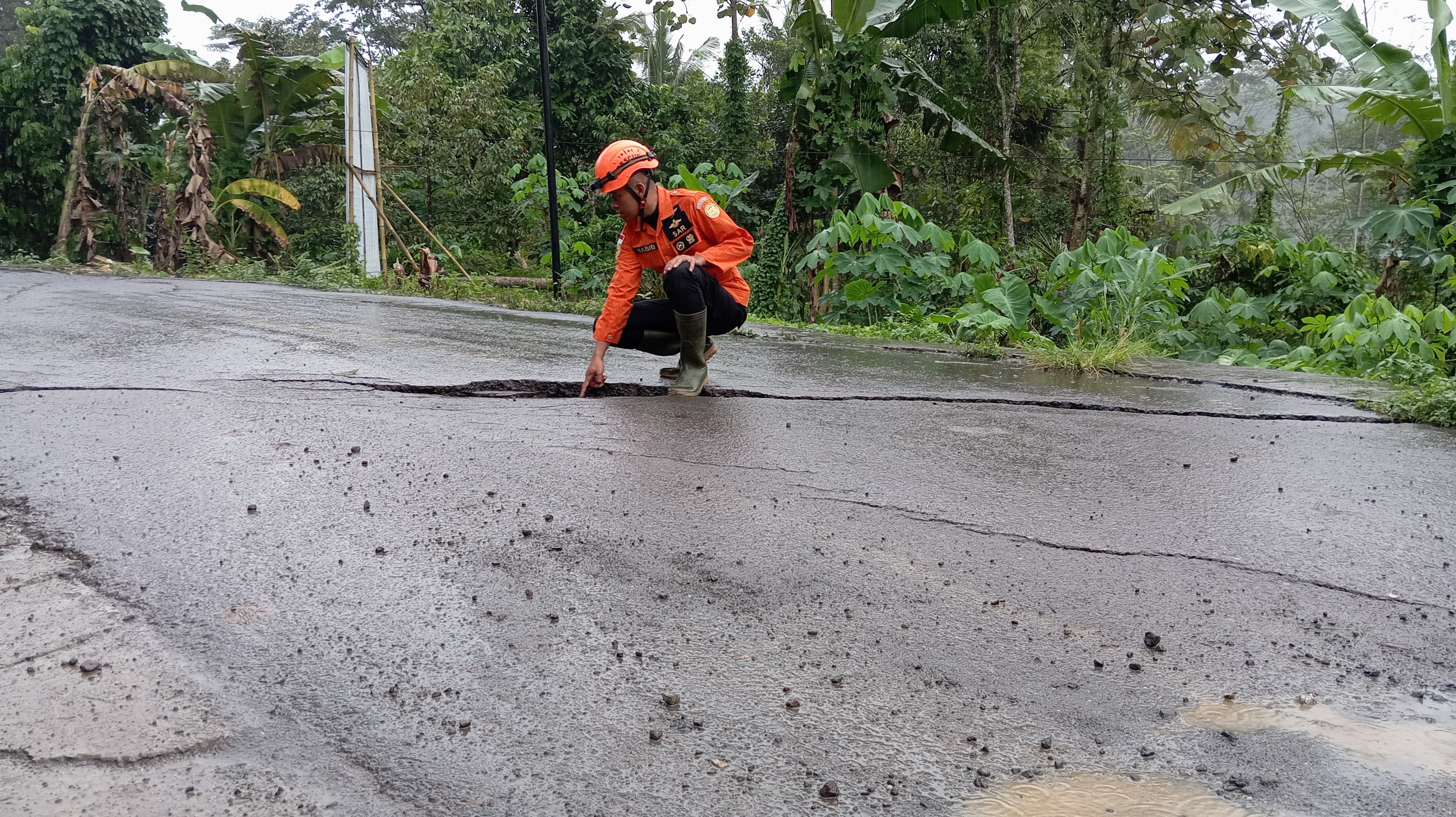 Petugas mengecek retakan tanah di jalur utama di Desa Medono, Kaliwiro.