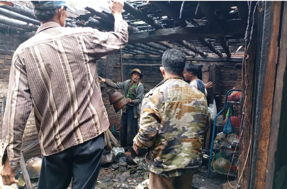 Warga Dusun Dadapan, Kaliangkrik, Kabupaten Magelang berusaha memadamkan api yang melalap rumah Mbah RIbut, Kamis  (9/1/2025).