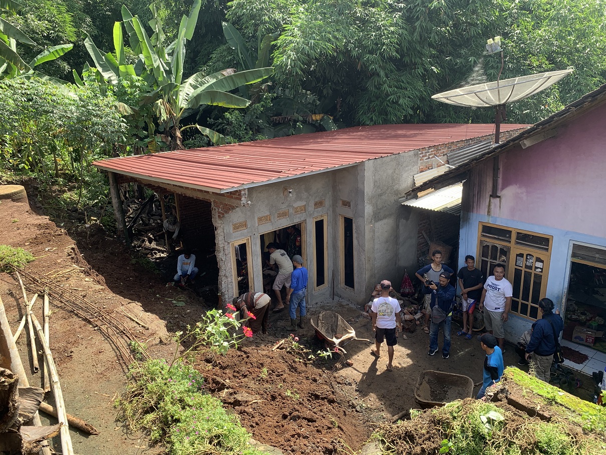 Warga Dusun Gemawang, Desa Sanggrahan, Kranggan, saat membersihkan material tanah longsor di rumah milik Saryadi.