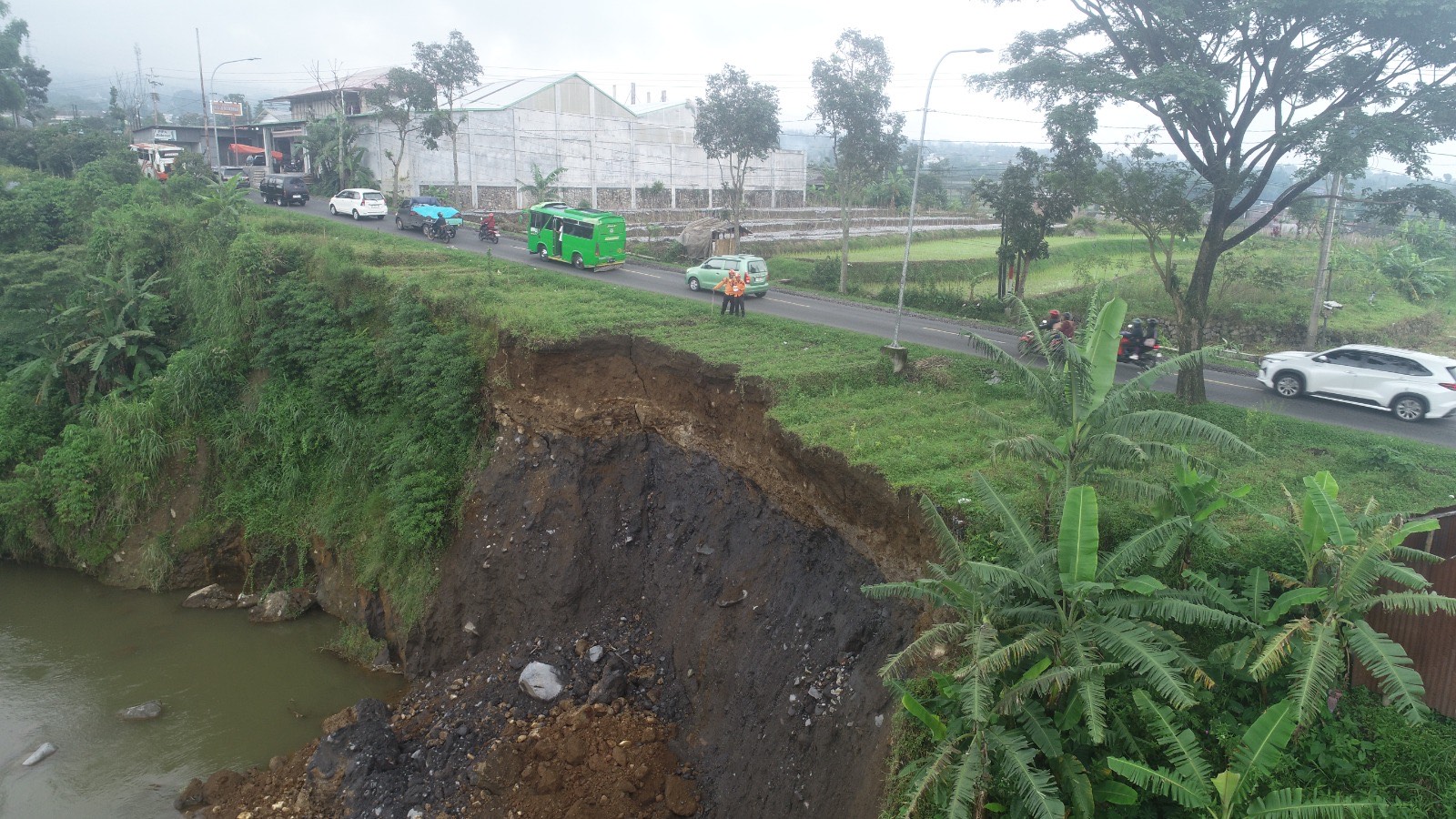 Kondisi Jalan Raya Parakan-Wonosobo di wilayah Desa Caturanom, Parakan yang tergerus longsor akibat banjir Sungai Galeh.