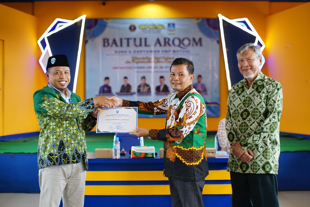 Sekretaris PDM Kota Magelang Salamun menyerahkan predikat Unggul Utama kepada Kepala SMP Muhammadiyah 1 Alternatif Kota Magelang Wasiun.