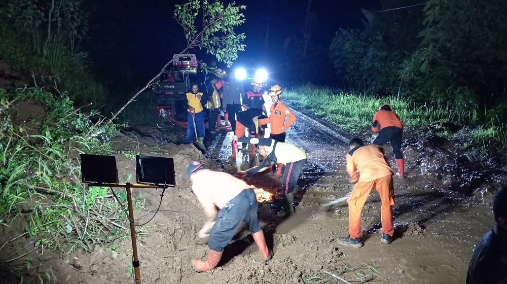 Petugas BPBD Kabupaten Wonosobo membersihkan material longsor yang sempat menutup Jalan Wadaslintang-Selokromo.