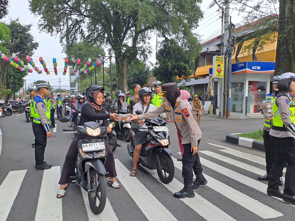 Kapolres Magelang Kota AKBP Anita Indah Setyaningrum membagikan takjil kepada pengguna jalan, yang melintas di depan Mapolres Magelang Kota, Rabu (5/3/2025).