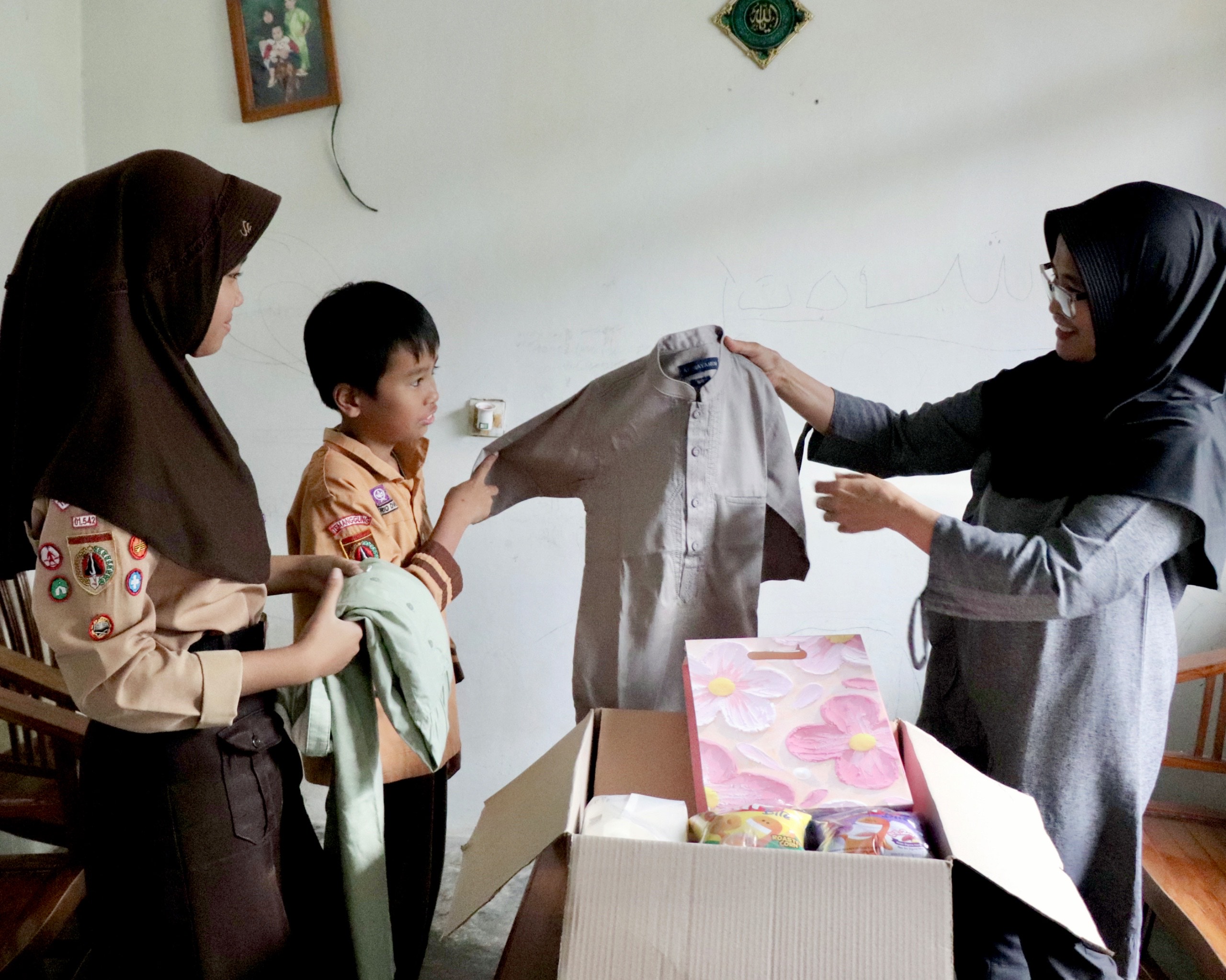 Panca Dewi menyerahkan baju lebaran untuk Jhan dan Satrio di rumahnya Liingkungan Krikil Walitelon Selatan Temanggung.