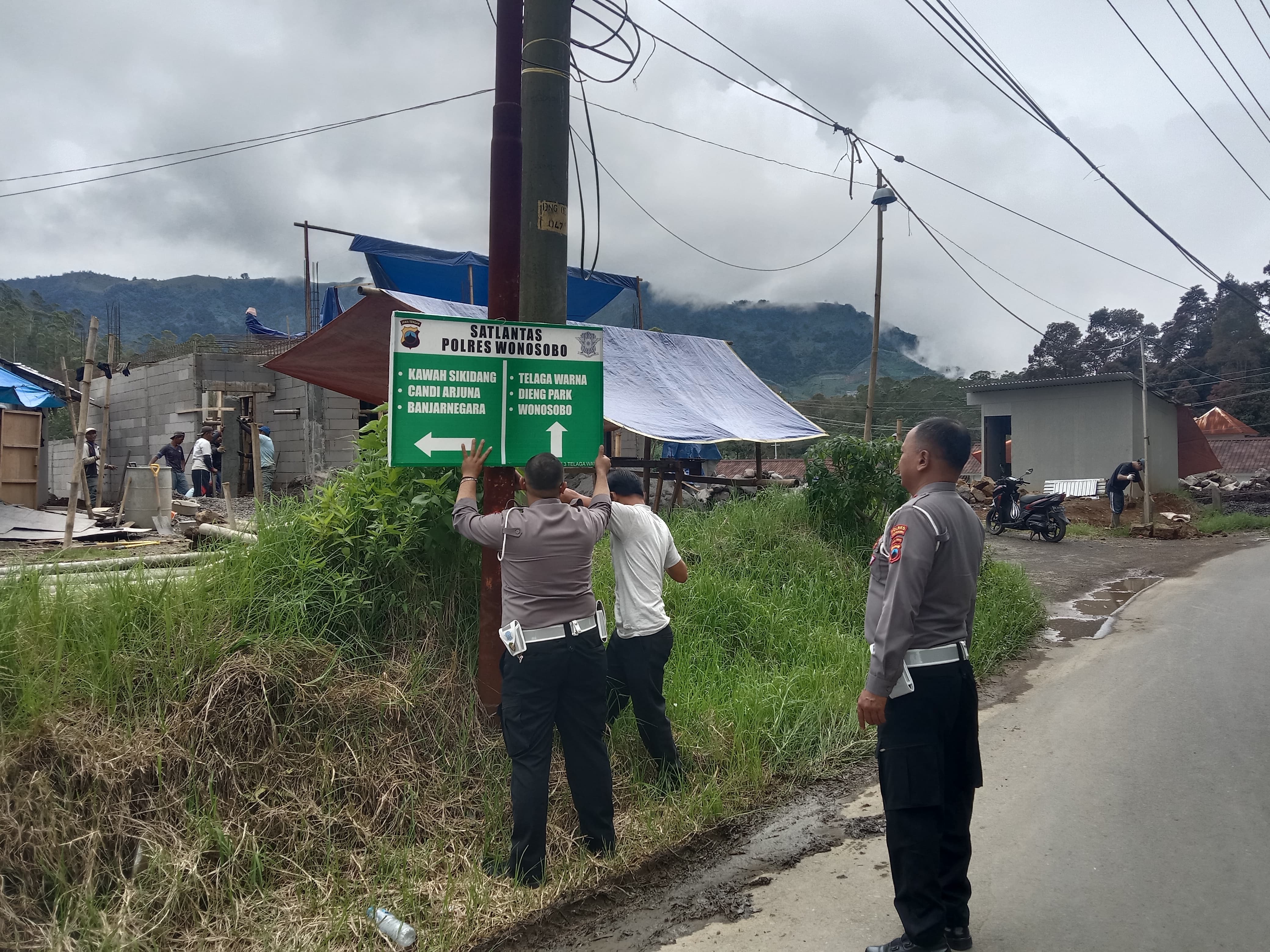 Petugas dari Satlantas Polres Wonosobo memasang rambu-rambu.