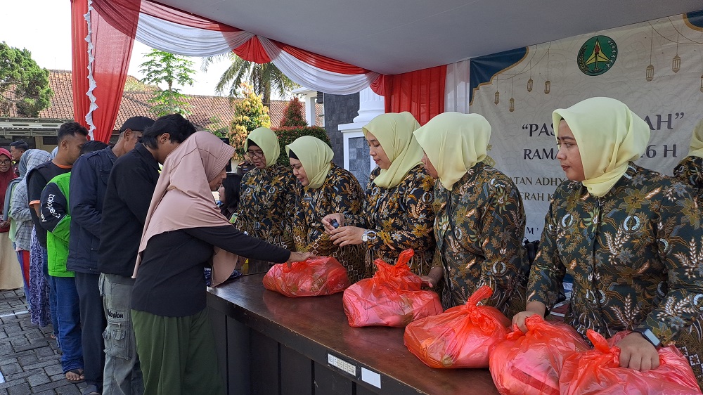 Warga antre mendapatkan paket sembako di pasar murah yang digelar Kejaksaan Negeri Kabupaten Magelang, Jumat (21/3/2025).