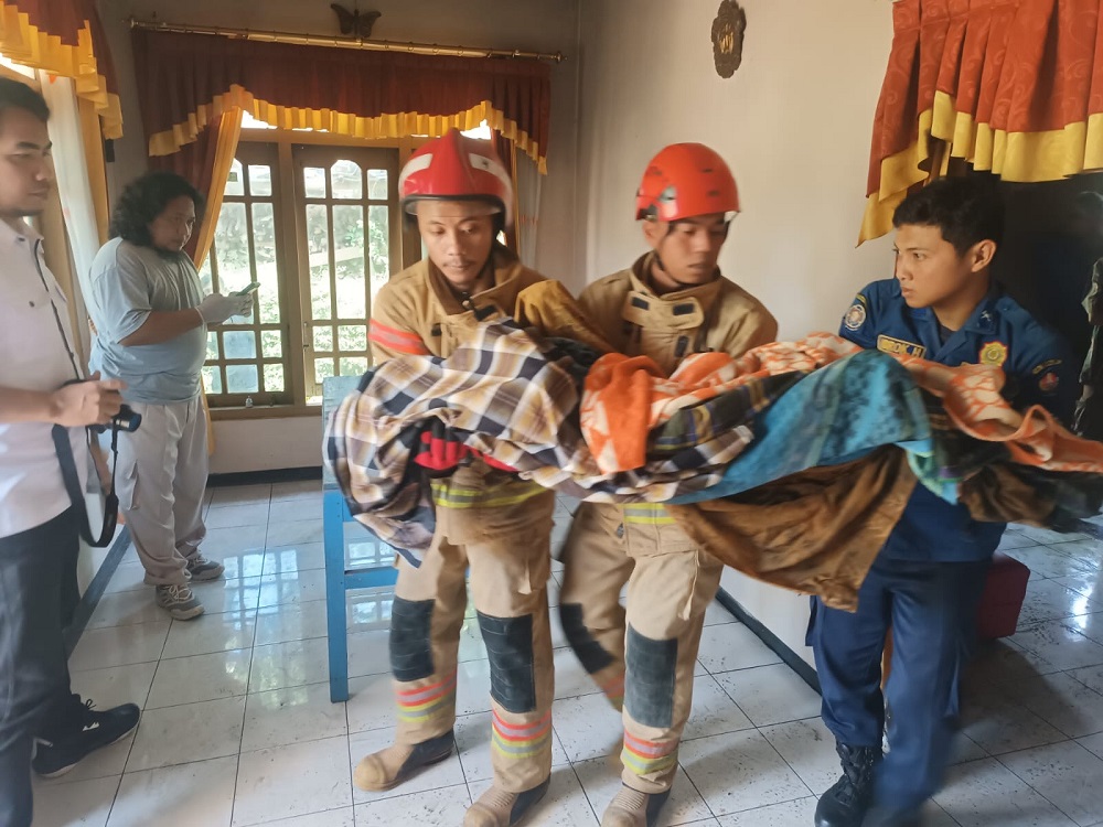 Petugas Damkar Temanggung saat mengevakuasi korban Mujito yang tewas terbakar di kamarnya di Desa Kebumen, Pringsurat, Selasa (8/4/2025).