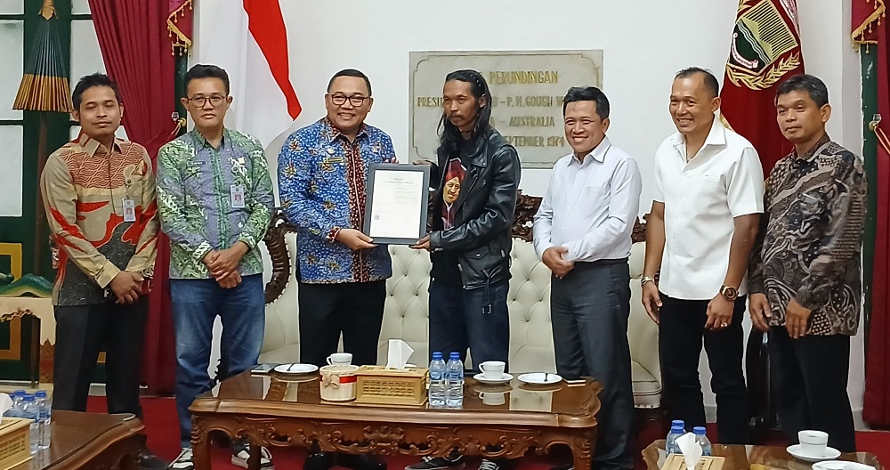 Kepala Kanwil Kemenkum Jateng Heni Susila Wardoyo menyerahkan sertifikat hak cipta kepada seniman patung biawak Ariyanto disaksikan Bupati Wonosobo Afif Nurhidayat.