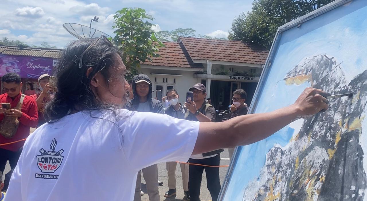 Aksi live painting seniman Rejo Arianto di dekat patung biawak di Krasak, Selomerto menyita perhatian masyarakat.