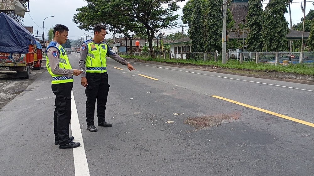 Petugas Satlantas Polresta Magelang menunjukkan lokasi kecelakaan yang menewaskan pengendara motor di depan halte Patal Secang, Kabupaten Magelang, Jumat (16/5/2025)