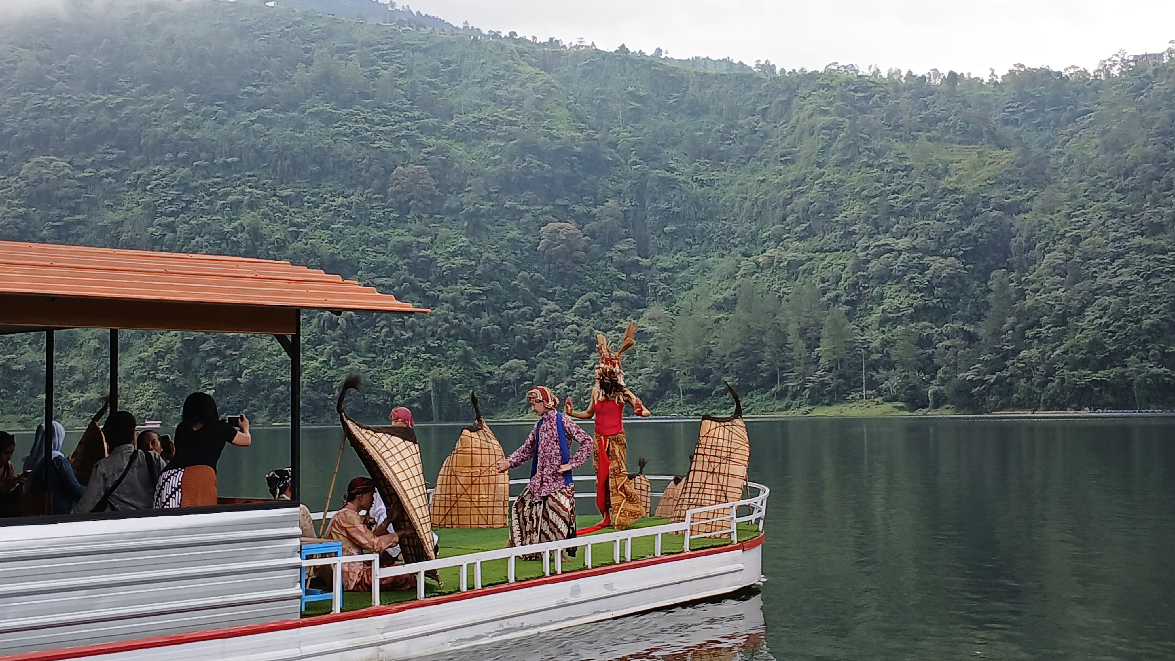 Penari lengger menari di atas perahu di Telaga Menjer diiringi bundengan. Musik ini asli Wonosobo.