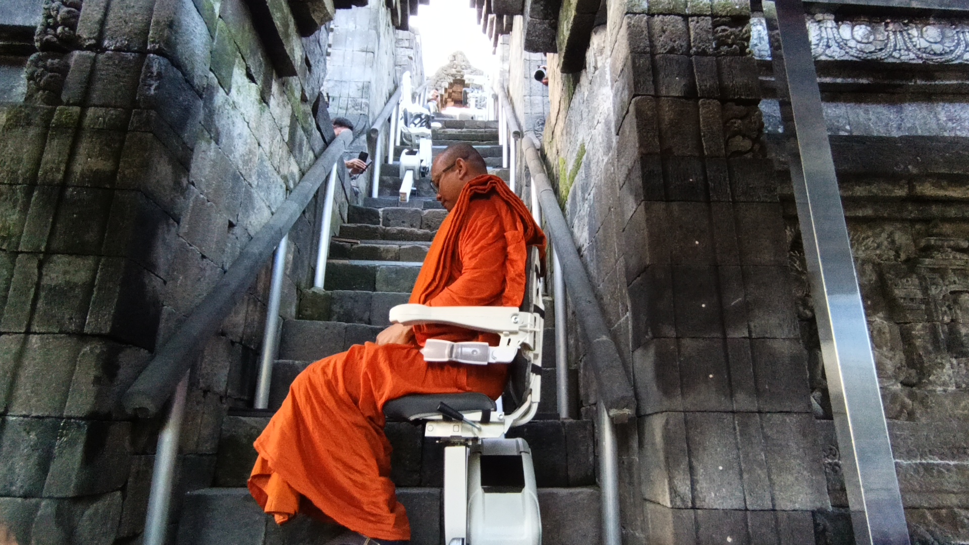 Biksu menaiki stairlift  di Candi Borobudur yang digunakan untuk fasilitas tambahan menyambut kedatangan Presiden Prabowo dan Presiden Prancis Emmanuel Macron, Kamis (29/5/2025).