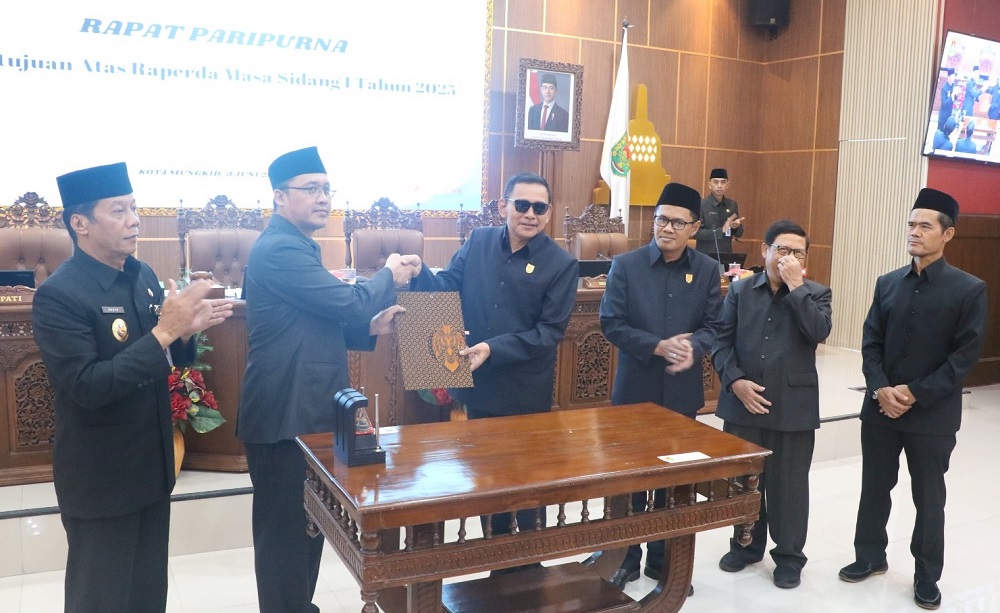 Ketua DPRD Kabupaten Magelang Sakir dan Bupati Grengseng Pamuji memegang naskah empat Raperda yang disetujui dalam Rapat Paripurna yang diselenggarakan di Gedung DPRD Kabupaten Magelang, Selasa (3/6)