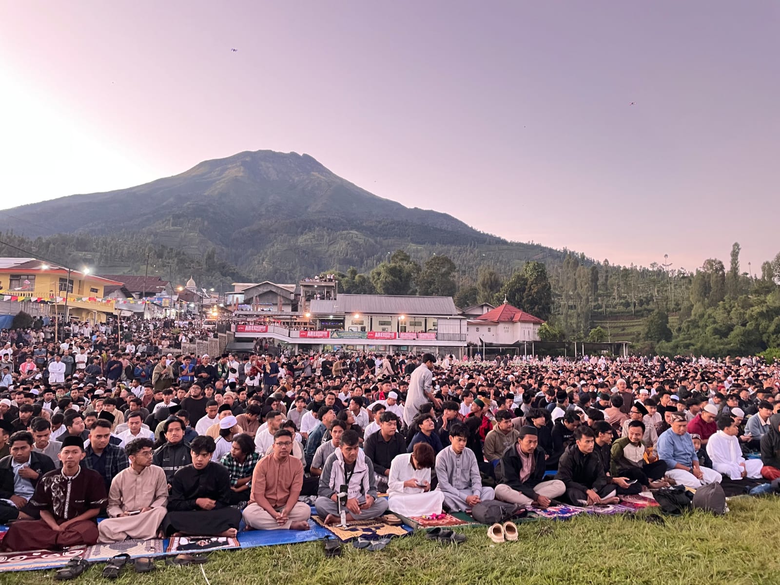 Jemaah salat Idul Adha 1446 H di lapangan Dusun Garung Desa Butuh Kalikajar Wonosobo dengan latar Gunung Sumbing dan view depan Gunung Sindoro, Jumat (6/6/2025).