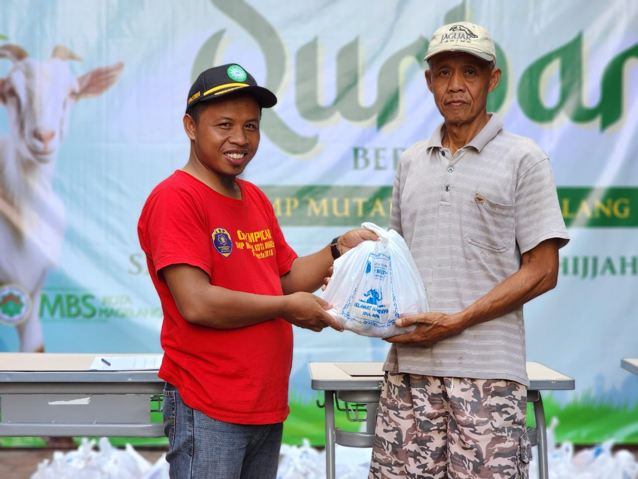 Kepala SMP Mutual Kota Magelang Wasi&rsquo;un menyerahkan daging kurban kepada masyarakat sekitar sekolah, Sabtu (7/6/2025).