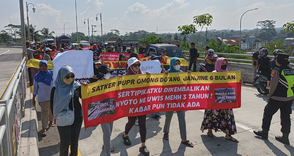 Puluhan warga menggelar aksi damai menuntut sertifikat sisa tanah imbas proyek pembangunan flyover Canguk Kota Magelang, Minggu (15/6/2025).