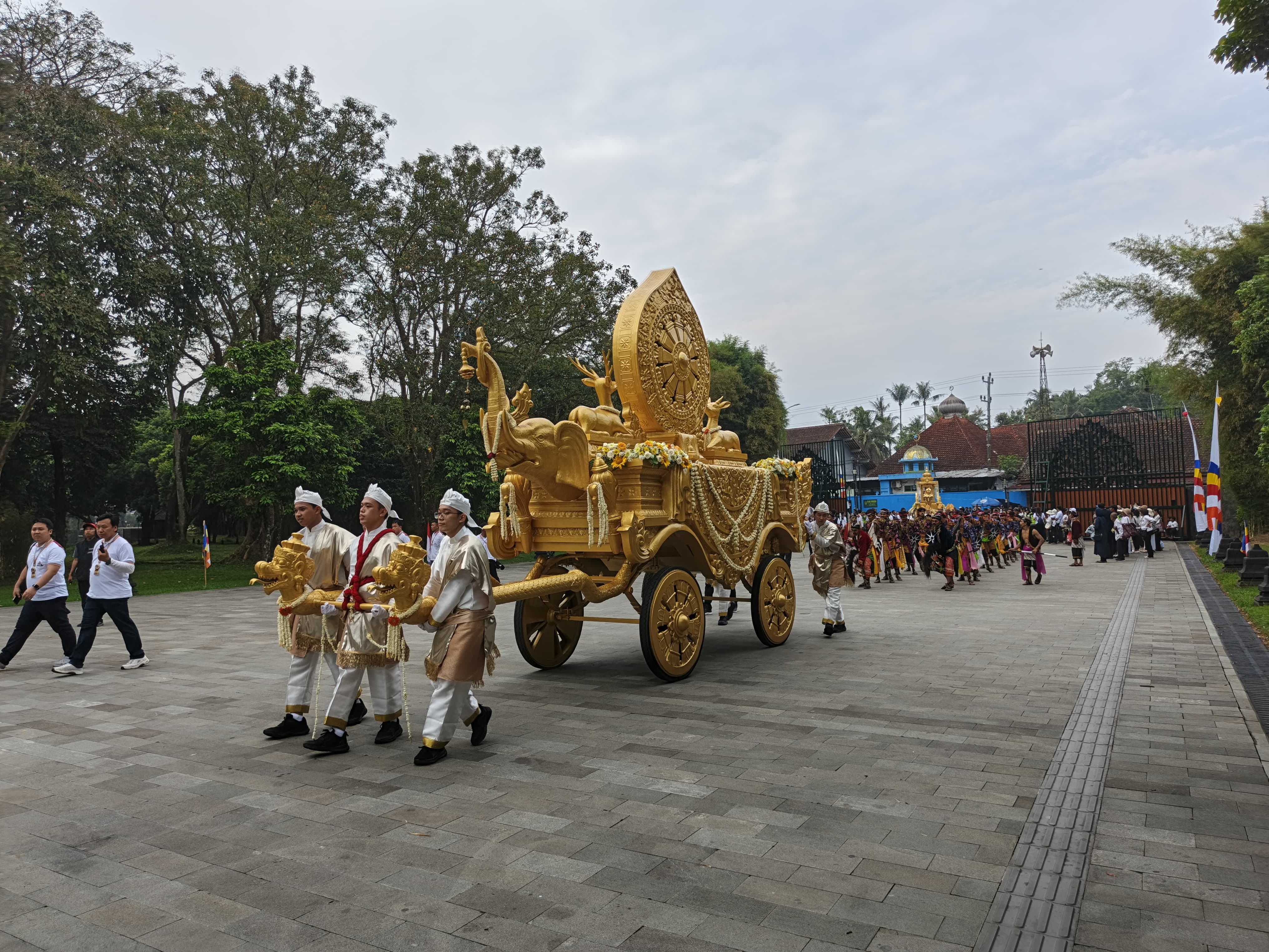 Umat Buddha mendorong kereta kencana  saat perayaan Asalha Mahapuja di Candi Borobudur, Magelang, Minggu (6/7/2025).