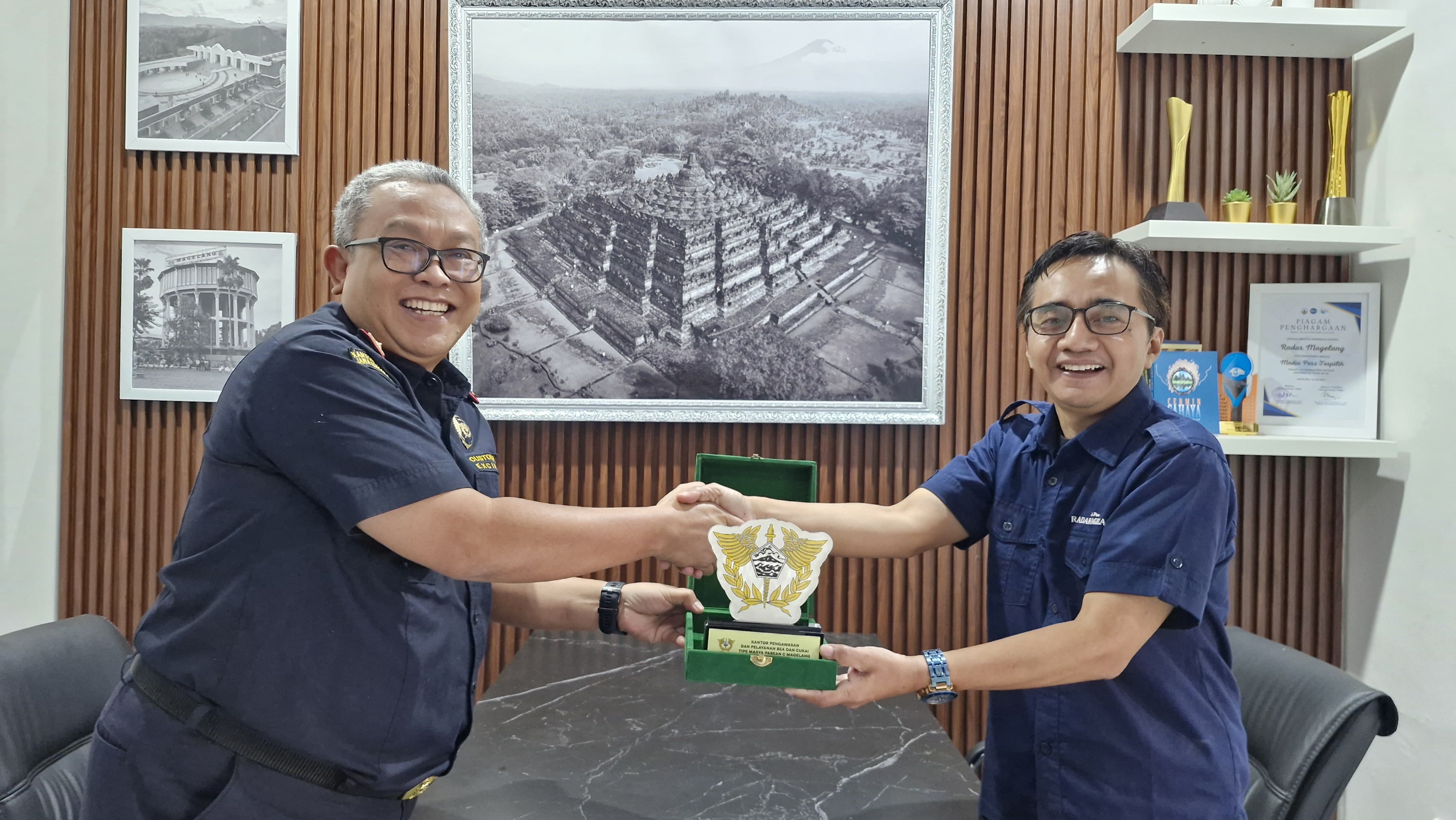 Kepala Kantor Bea Cukai Magelang Imam Sarjono (kiri) menyerahkan cinderamata kepada Pemimpin Redaksi Jawa Pos Radar Magelang Arif Riyanto saat media visit, Rabu (16/7/2025).