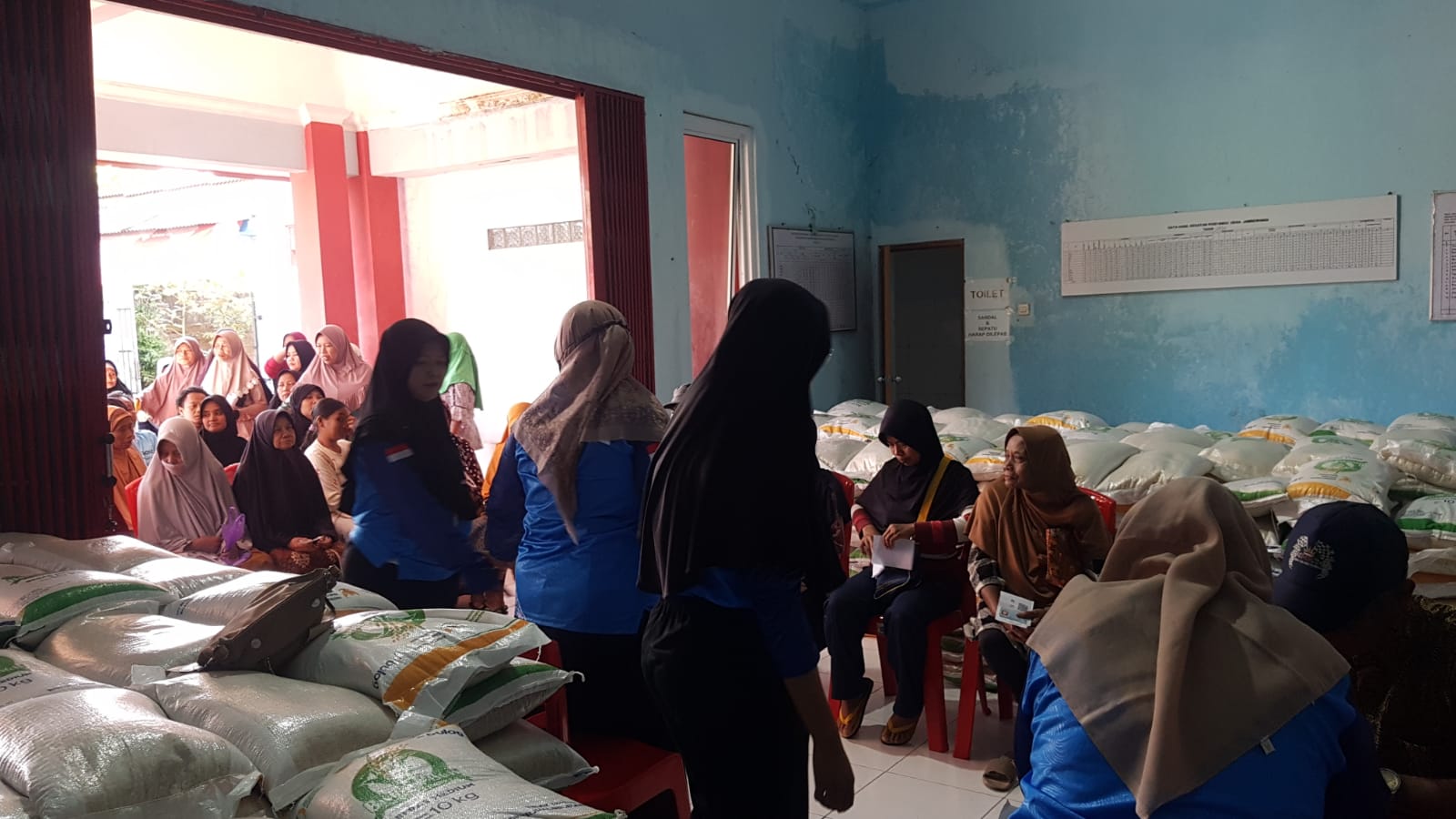 Warga Temanggung antre menerima bantuan pangan beras oleh Bulog pada Jumat, 18 Juli 2025.