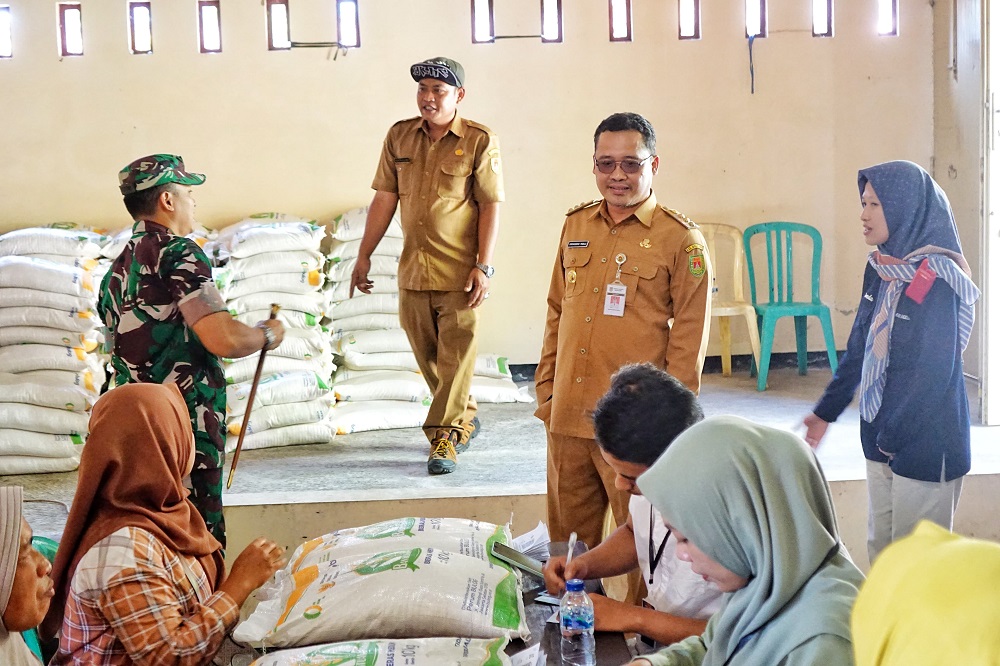 Bupati Magelang Grengseng Pamuji saat menyerahkan bantuan pangan berupa beras sebanyak 10 kg kepada masyarakat dengan kriteria kurang mampu di Desa Tempak, Candimulyo.