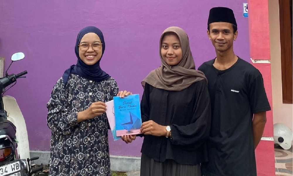 Salah satu calon pengantin menyerahkan buku di perpustakaan rumah baca di Desa Salam.