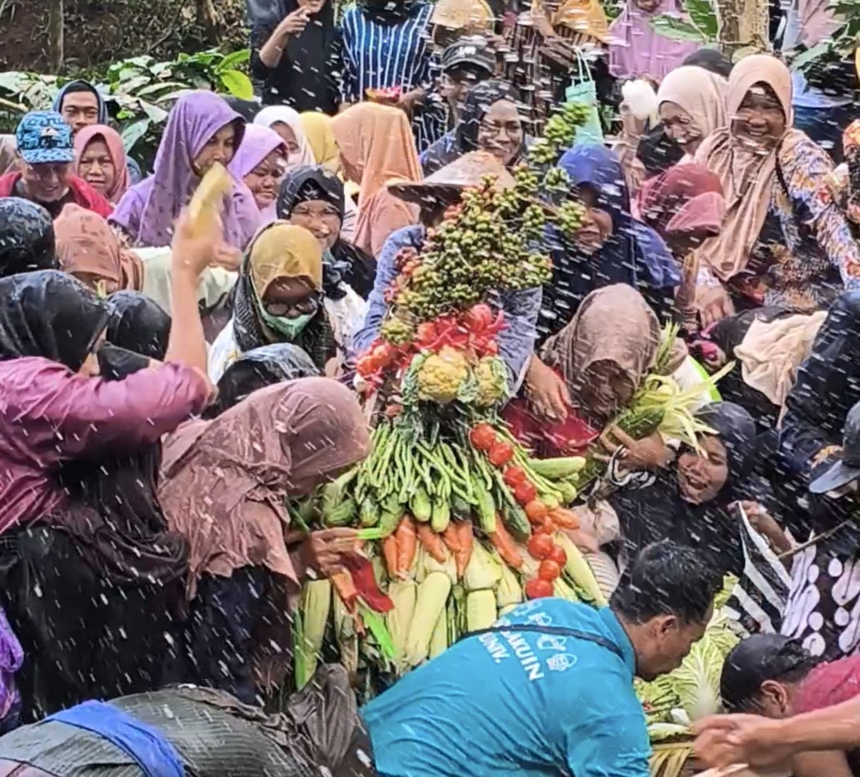 Warga desa berebut gunungan dan kupat untuk ngalap berkah dalam tradisi sadranan Kali Lenging di Desa Ngemplak, Kandangan.