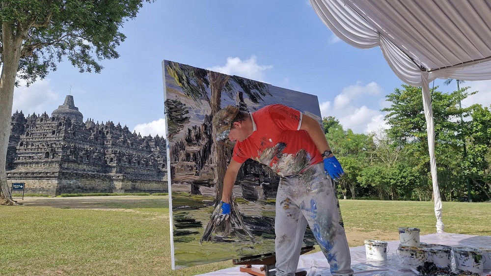 Pelukis berdarah Jerman, Christopher Lehmpfuhl melukis Candi Borobudur dengan jarinya, Senin (4/8/2025).&nbsp;
