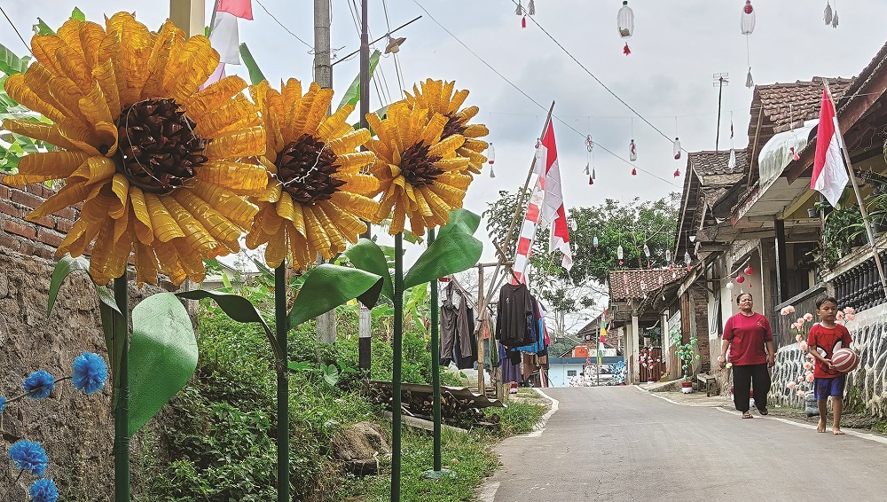Bunga-bunga berbahan plastik menghiasi jalan di Dusun Ngletoh, Desa Payaman, Kecamatan Secang, Kabupaten Magelang untuk memeriahkan HUT Kemerdekaan RI.  &nbsp;