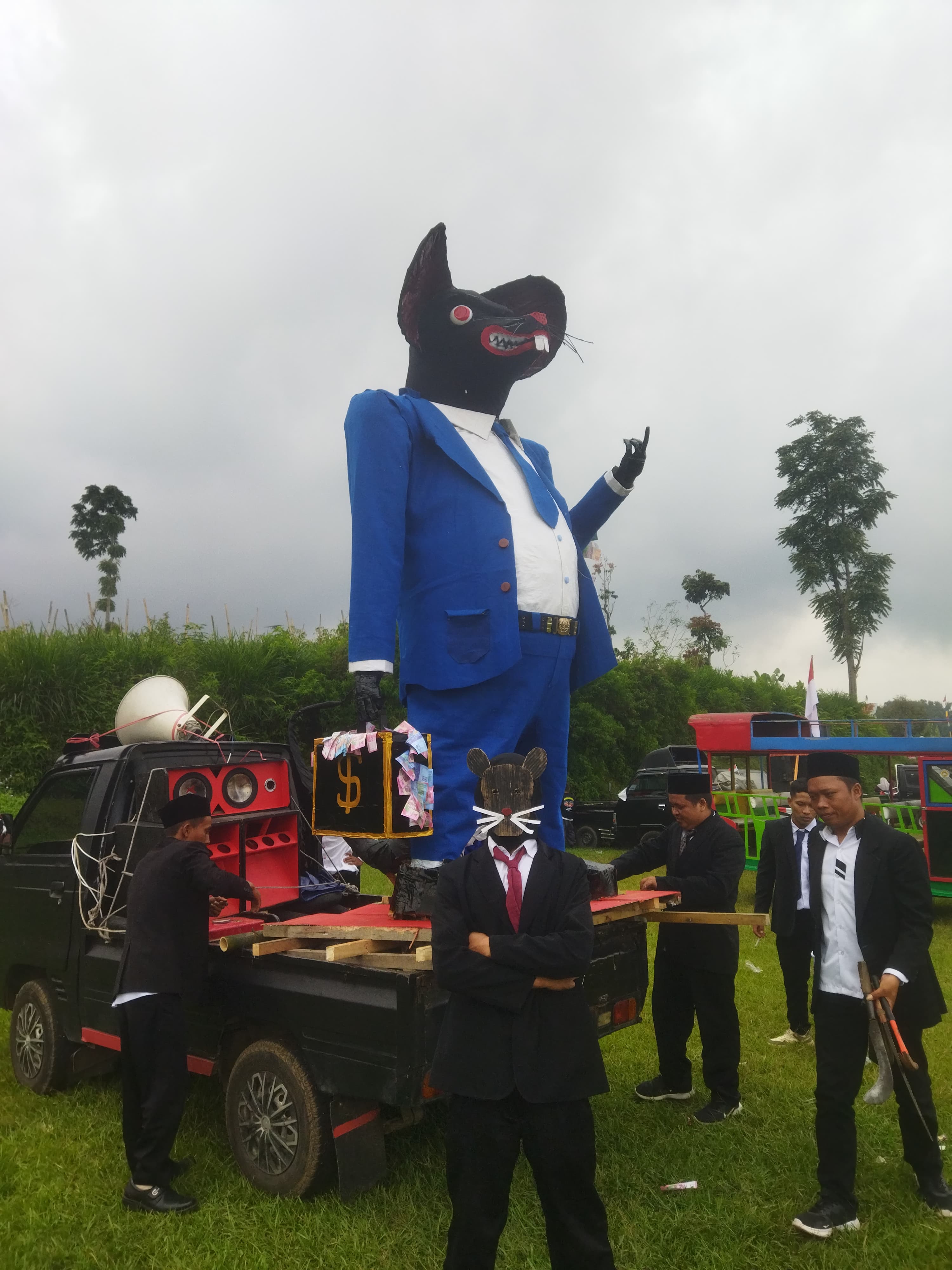 Ikon tikus kantor diusung oleh warga RT 5 RW 2 Sojopuro Mojotengah dalam karnaval kemerdekaan, Selasa (19/8/2025).