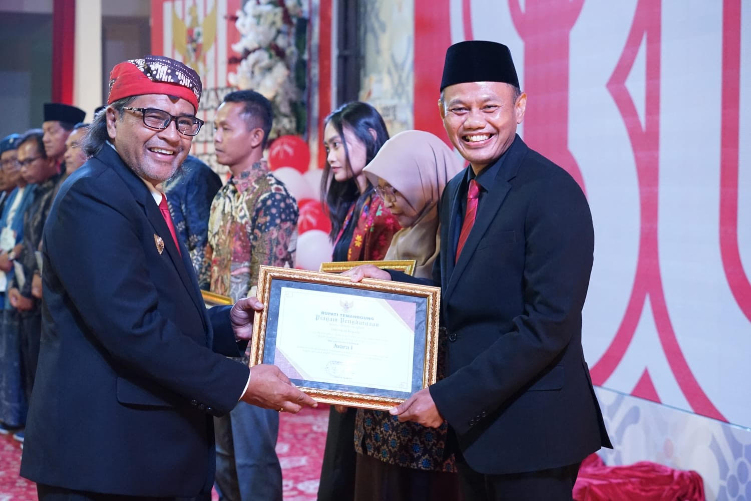 Bupati Temanggung Agus Setyawan menyerahkan penghargaan kepada Kepala DPMPTSP Dwi Sukarmei di Graha Bhumi Phala, Minggu (17/8/2025) saat resepsi HUT ke-80 RI.