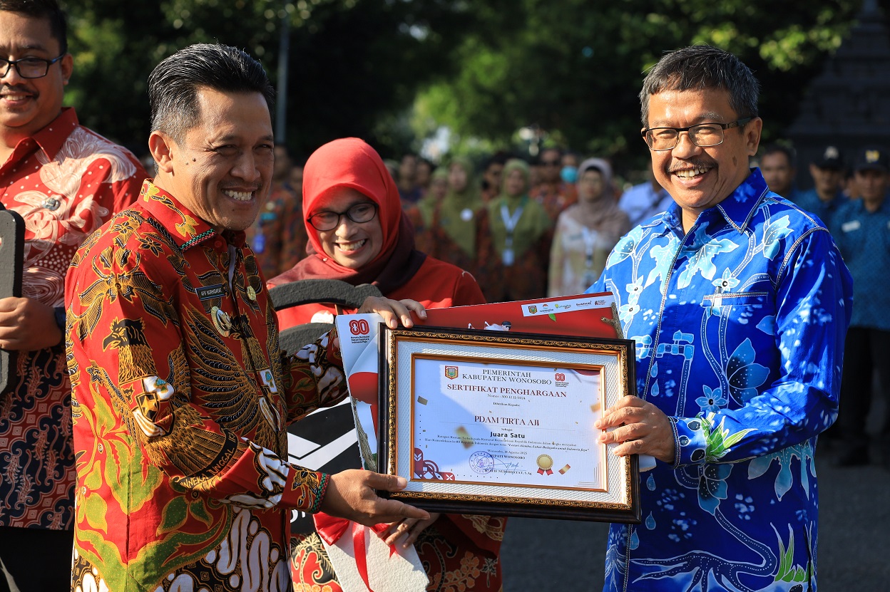 Bupati Afif Nurhidayat menyerahkan sertifikat penghargaan kepada Dirut PDAM Tirta Aji M Sjahid.