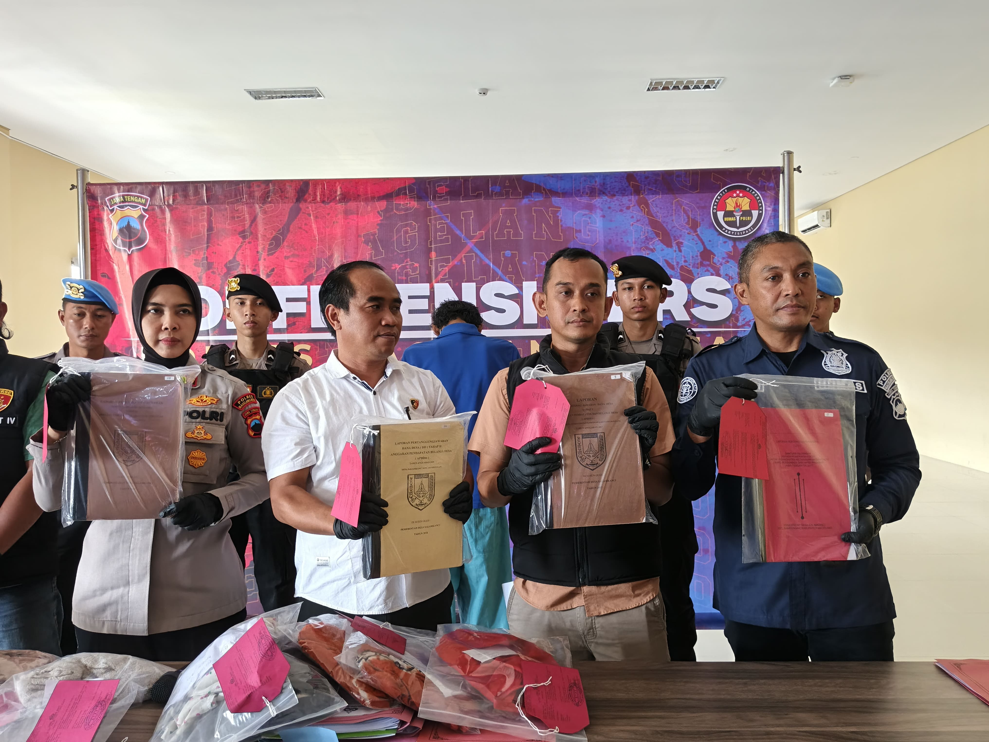 Polisi saat menunjukan barang bukti sejumlah laporan proyek yang dikorupsi oleh Kades Salamkanci Magelang.