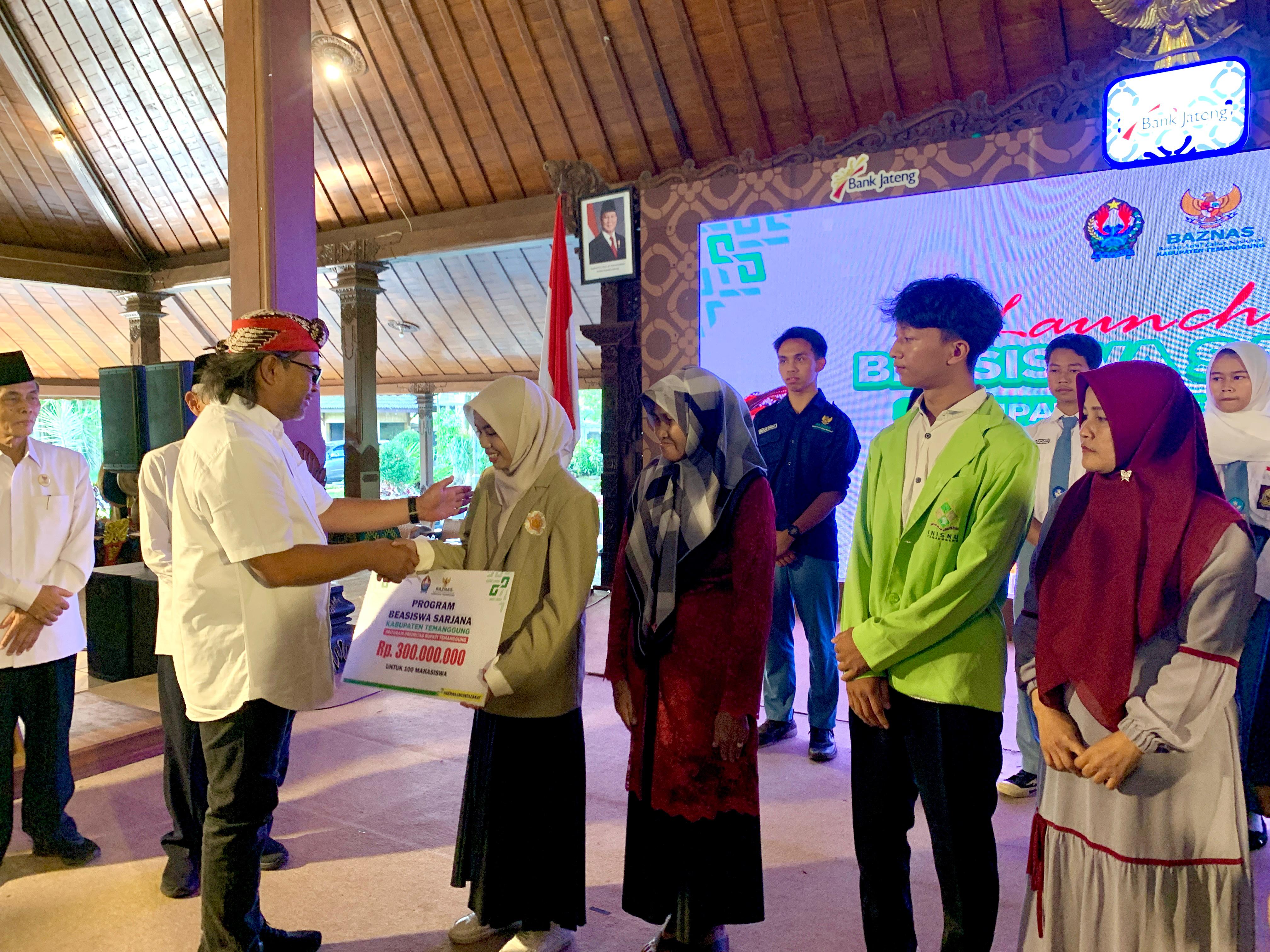 Bupati Temanggung Agus Setyawan menyerahkan beasiswa secara simbolis pada mahasiswa penerima.