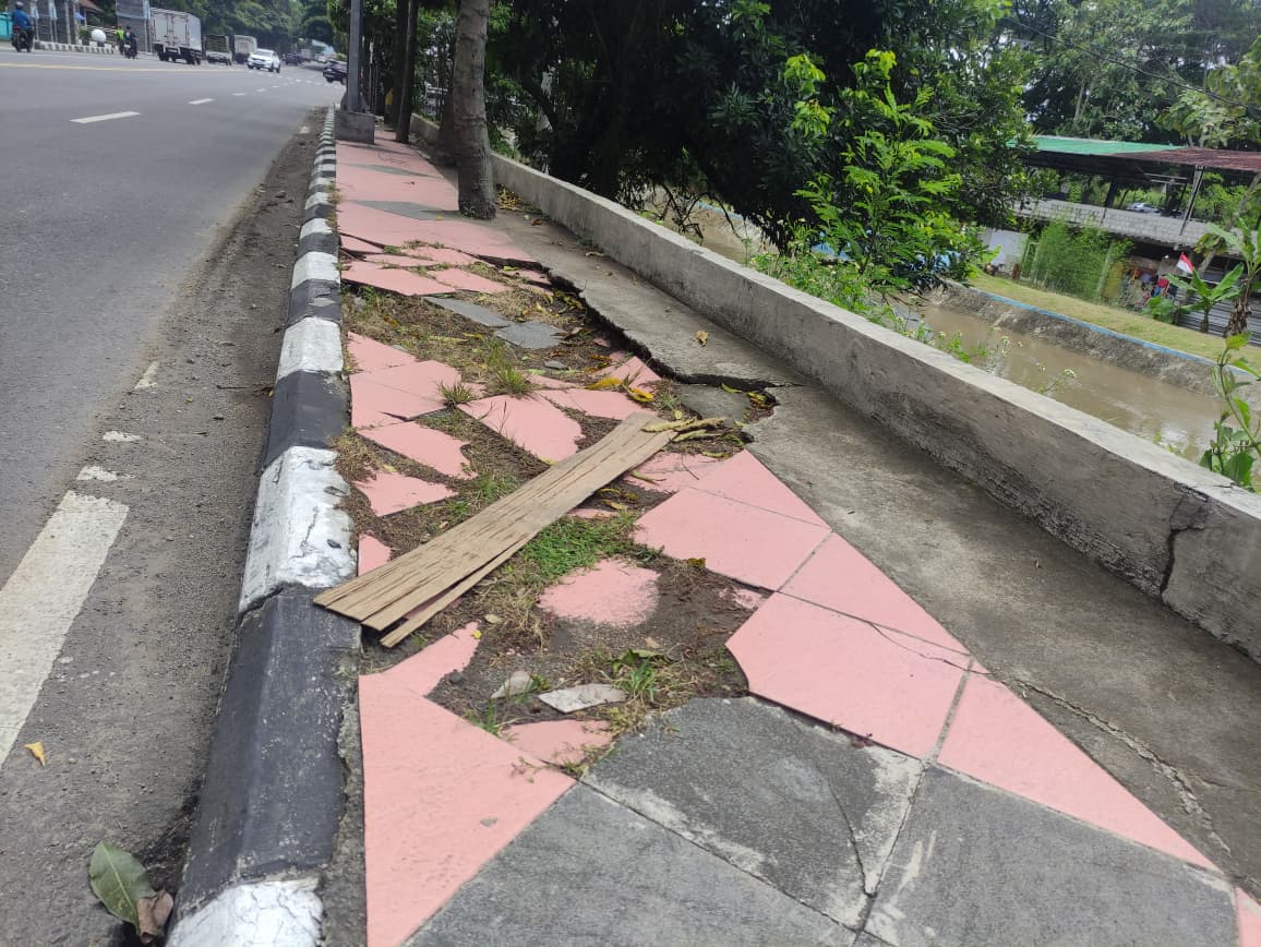 Trotoar retak dan ubin pecah di Jalan Raya Semarang&ndash;Jogja dekat Kampus Untidar Sidotopo. Kondisi yang mengganggu kenyamanan dan keselamatan pejalan kaki.