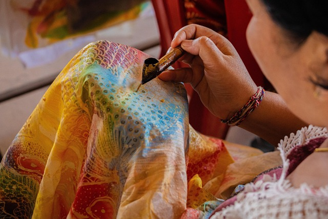 Seseorang sedang mencanting batik