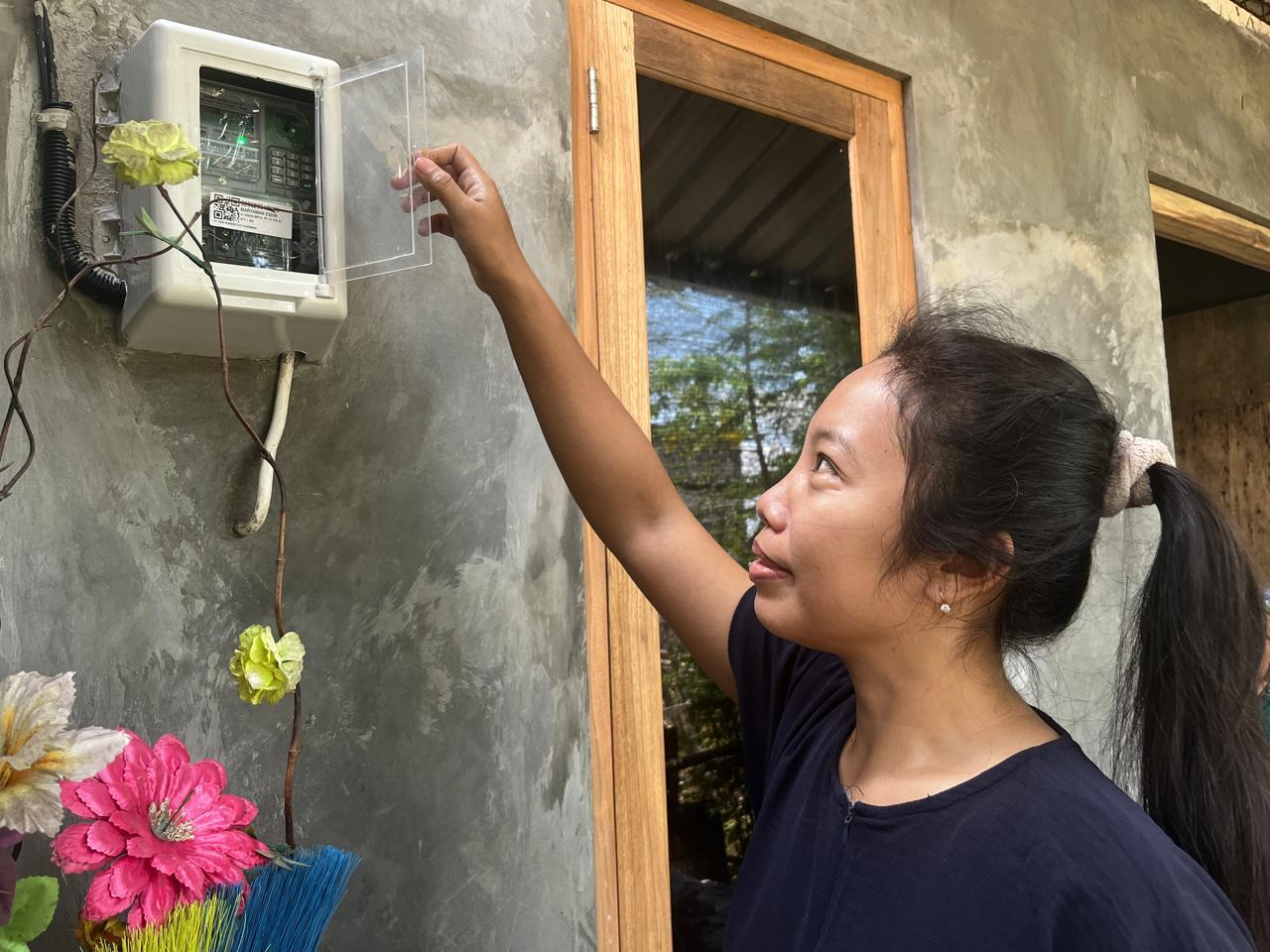 Warga Demak penerima manfaat  bantuan listrik dari Pemrov Jateng menunjukkan meteran listrik yang kini tak lagi anjlok.