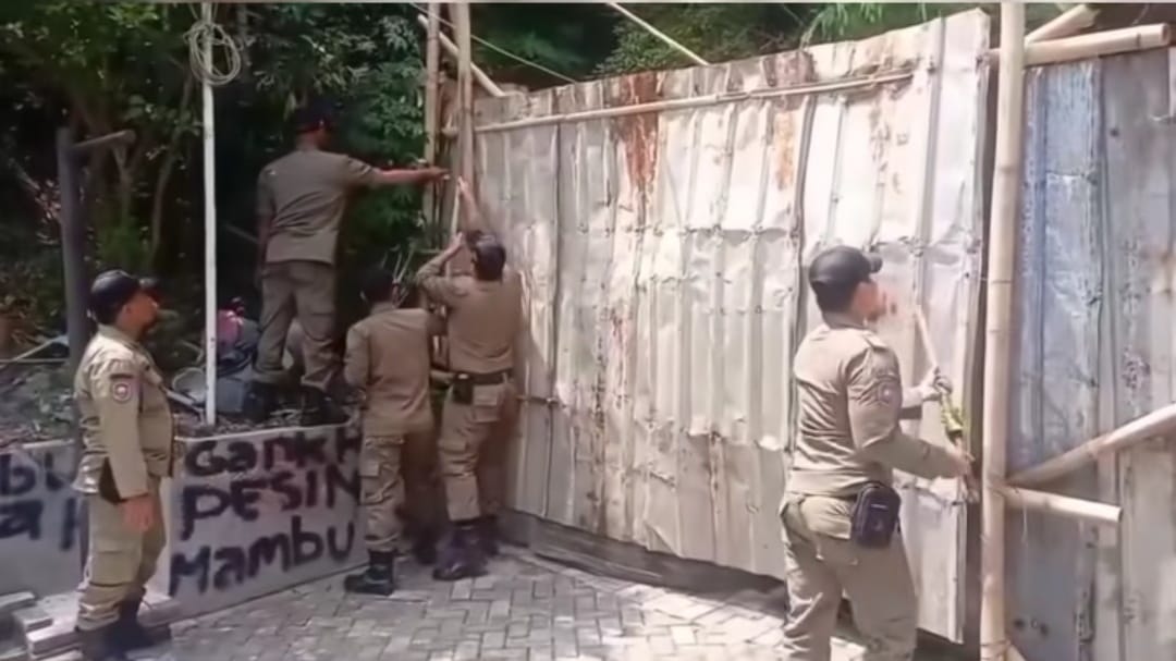 Satpol PP Kota Semarang membongkar pagar seng penutup akses jalan di Perumahan Sinar Waluyo, Senin (6/10/2025).