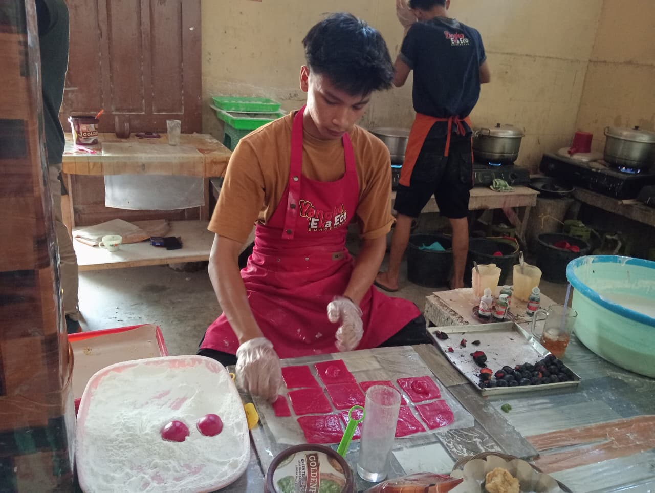 Seorang karyawan Yangko Eko Eco sedang membuat mochi strawberry