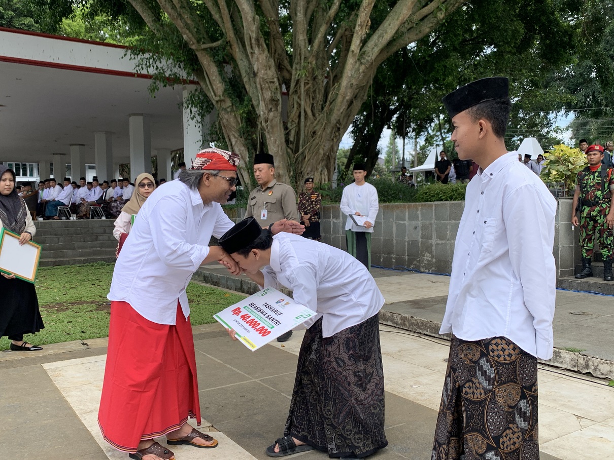 Bupati Temanggung Agus Setyawan memberikan beasiswa kepada santri secara simbolis usai upacara Hari Santri di Alun-alun Temanggung, Rabu (22/10/2025).