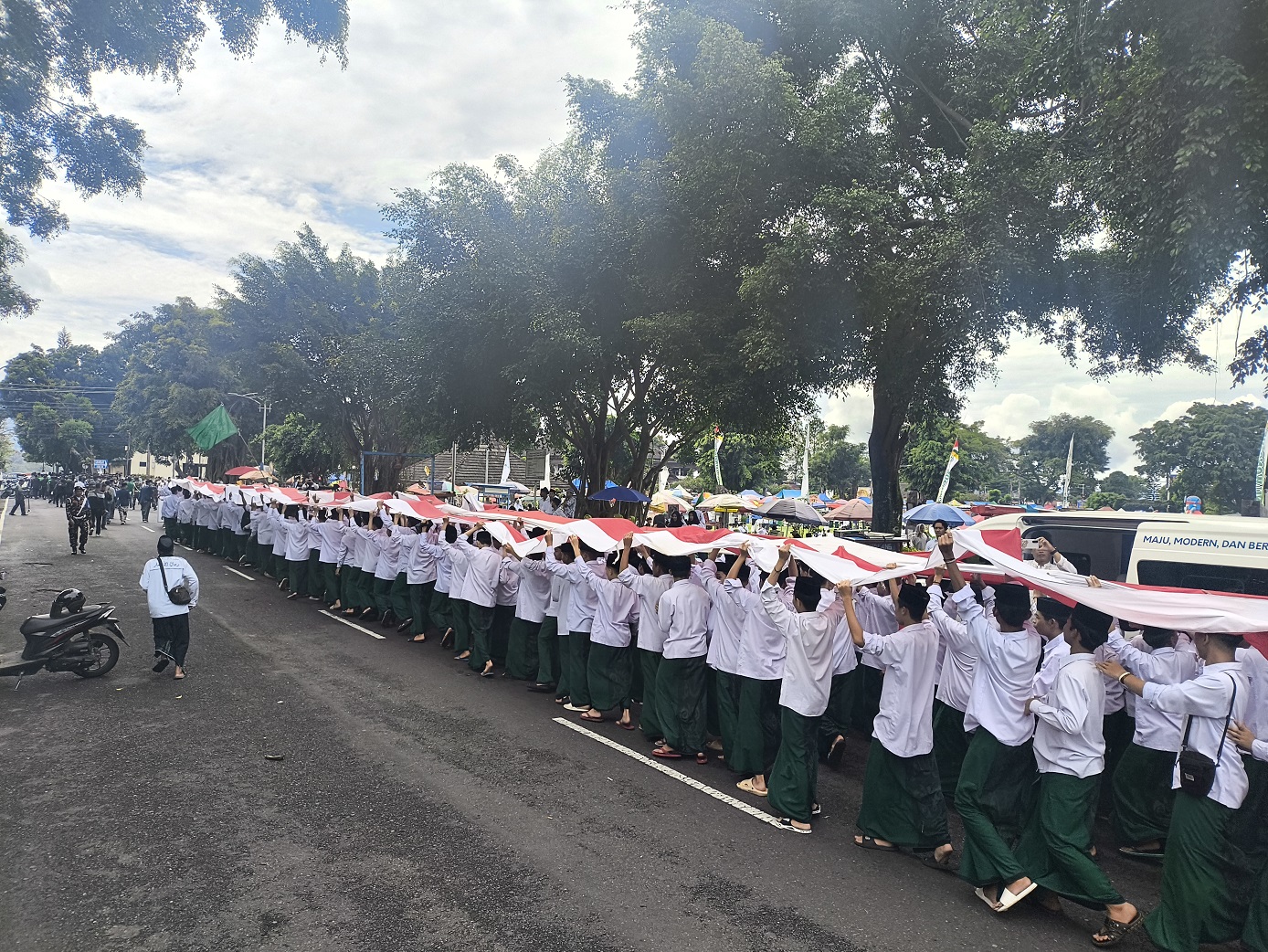 Ribuan santri membentangkan bendera berjalan menuju Alun-alun Wonosobo, Rabu (22/10/2025).