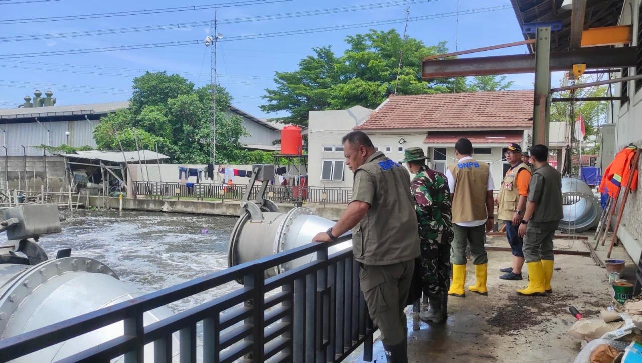 Petugas mengawasi pergerakan air yang dipompa untuk mengatasi banjir di Semarang.