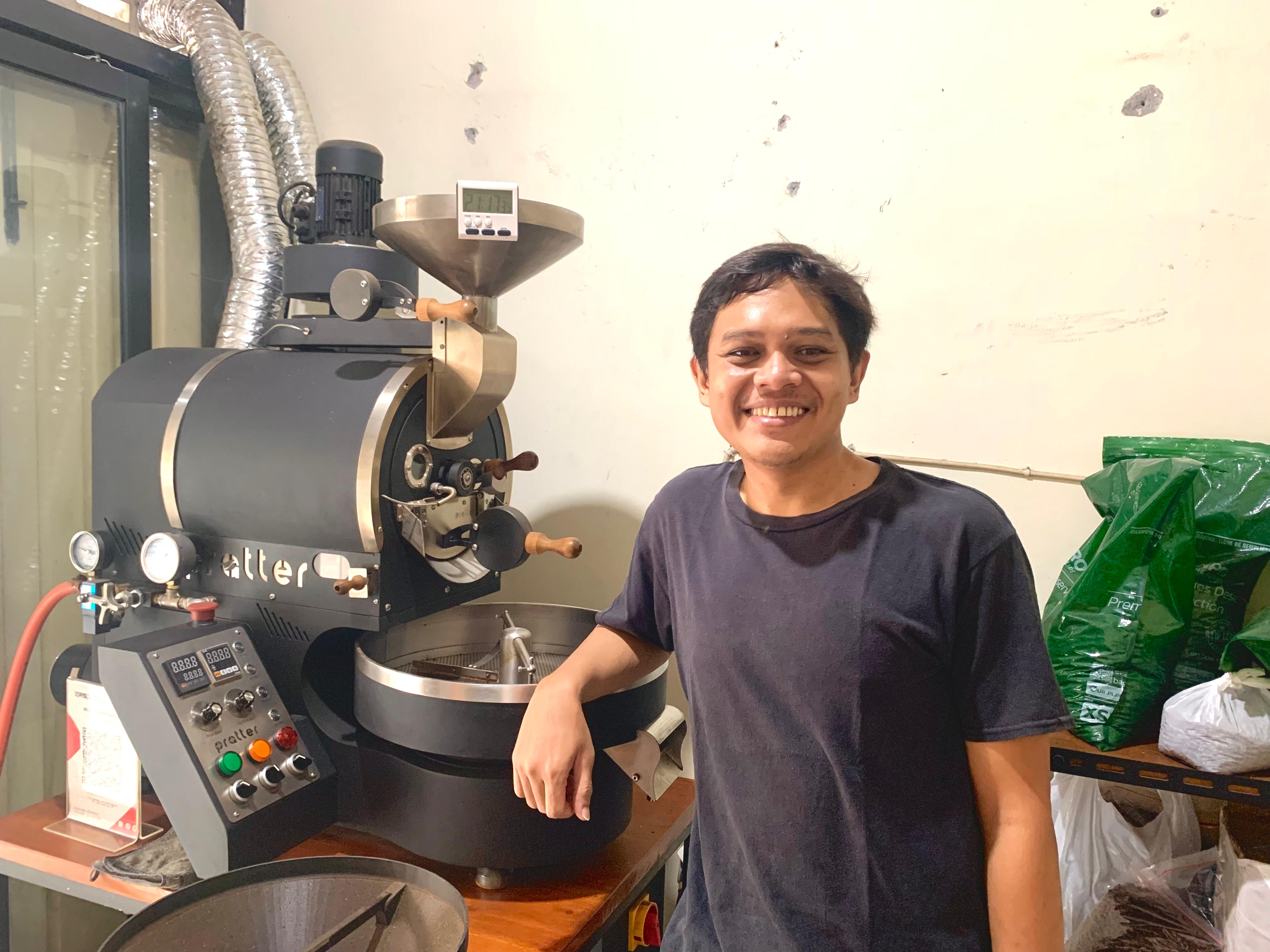 Raki pemilik Begik Roastery bersama mesin penggiling kopi miliknya