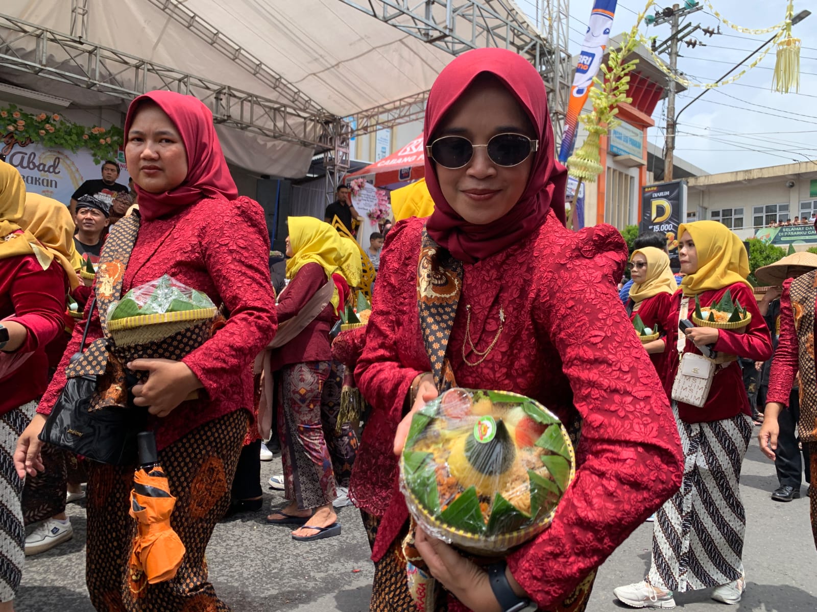 Kemeriahan momen 100 tahun Pasar Legi Parakan yang digelar Sabtu (8/11/2025). Ada kirab yang menarik dan ibu-ibu pedagang membawa makanan.