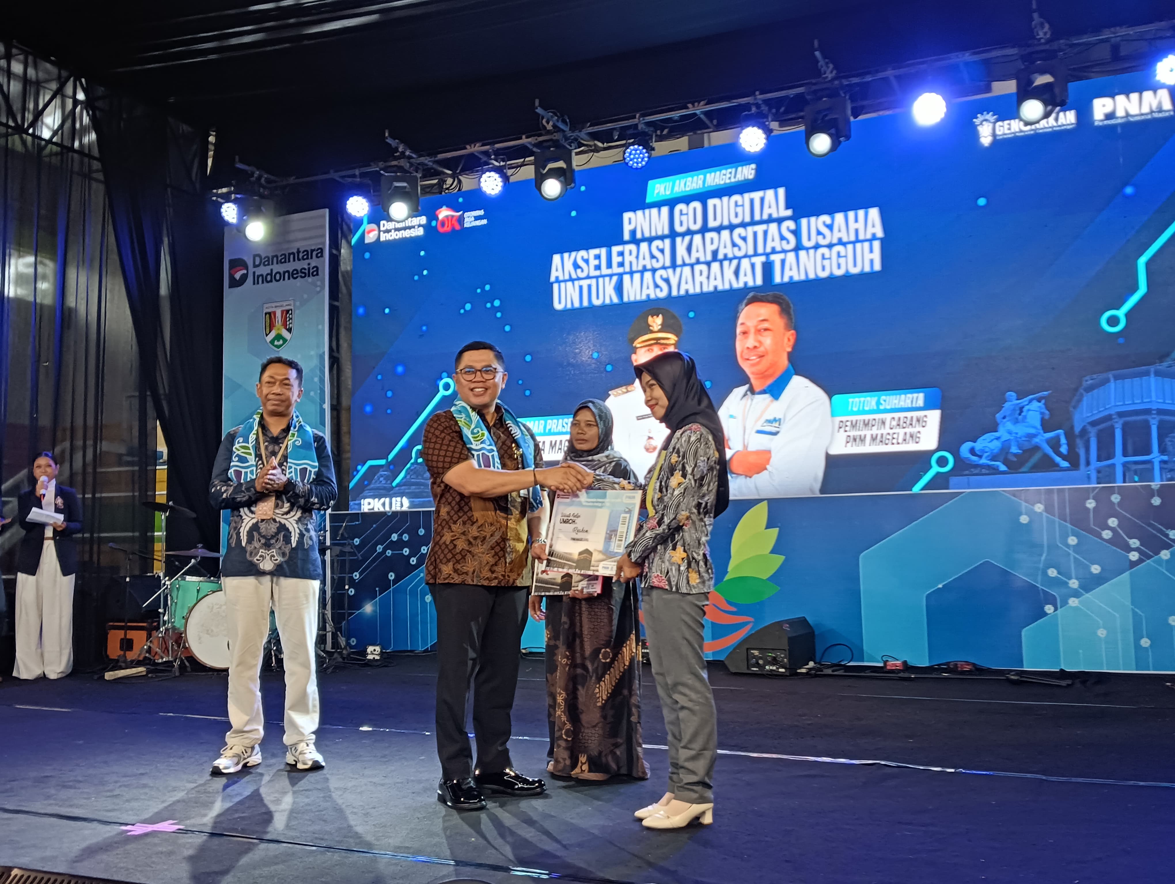 Wali Kota Magelang Damar Prasetyono menyerahkan hadiah umrah kepada dua nasabah PNM Mekaar, didampingi Kepala PNM Cabang Magelang Totok Suharta, Kamis (13/11/2025).