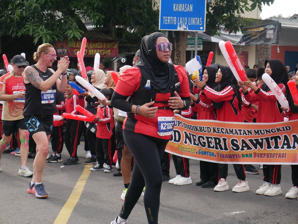 Sejumlah pelari Borobudur Marathon 2025 mendapatkan semangat dari para siswa SD Sawitan, Mungkid, Minggu (16/11/2025).