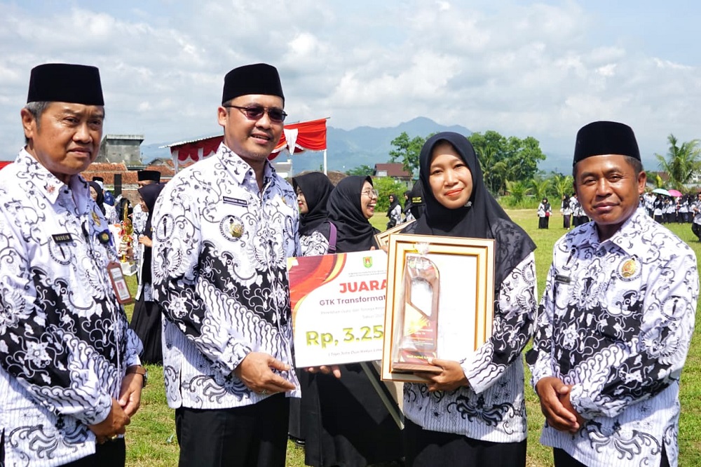 Bupati Magelang Grengseng Pamuji menyerahkan piala dan hadiah kepada guru saat upacara peringatan HUT ke-80 PGRI sekaligus Hari Guru Nasional tingkat Kabupaten Magelang, Selasa (25/11/2025).