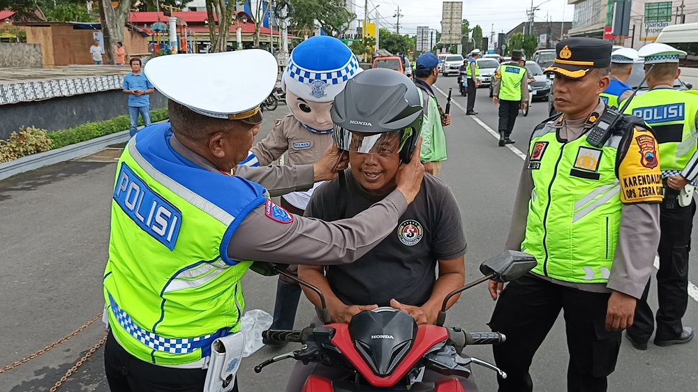 Aparat Satlantas Polres Magelang Kota bagikan helm gratis kepada pengendara  di Alun-alun Kota Magelang, Kamis (27/11/2025) pagi.