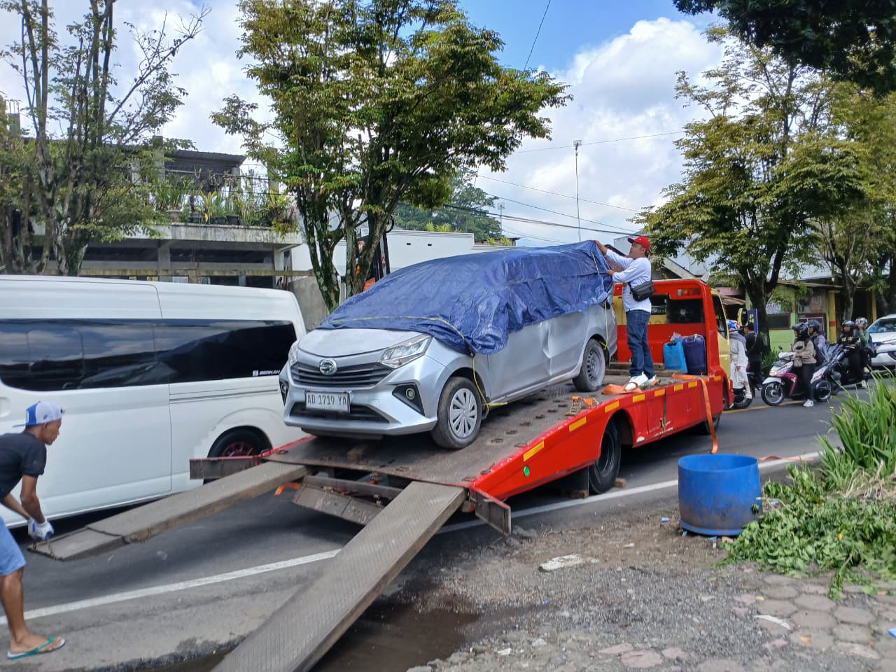 Mobil yang terbakar diangkut keluar dari SPBU Sidojoyo setelah sempat terbakar, Selasa (23/12/2025).