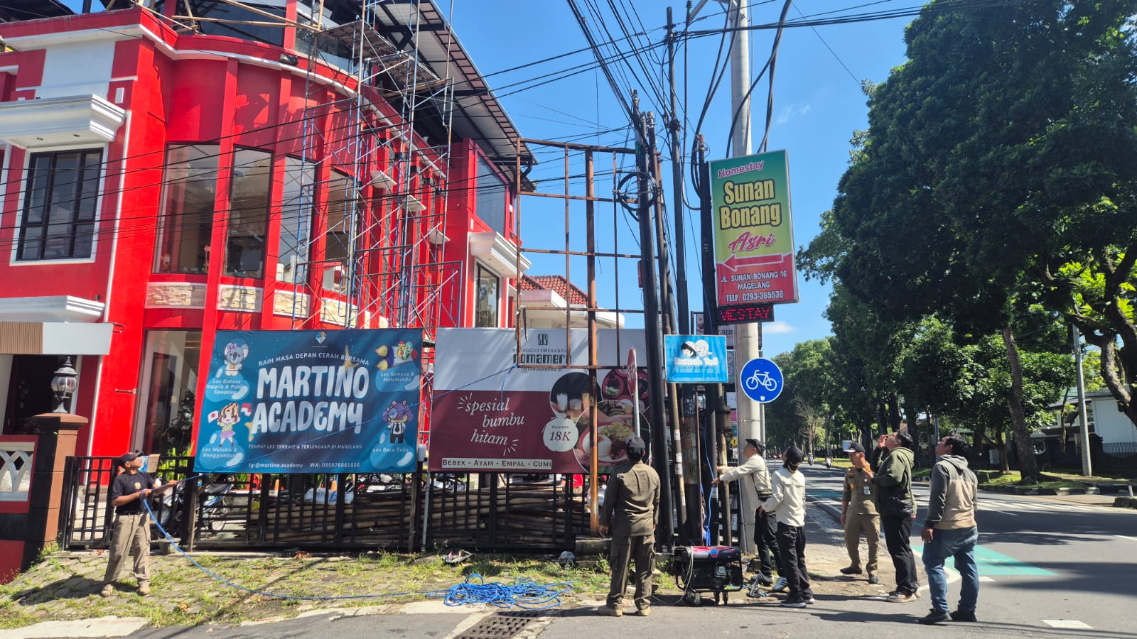 Penertiban baliho di sekitar  kawasan Alun-alun Kota Magelang ditertibkan, Senin (22/12/2025. Tampak petugas tengah menertibkan baliho di depan Akmil.